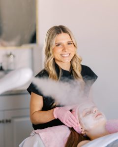 esthetician working on spa facial client with smoke