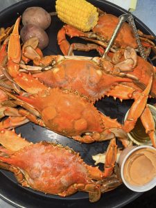 platter with crabs, potato's corn, dip, and nut cracker