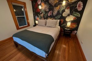 simple bedroom with accent wall behind the bed featuring larger-than-life butterflies