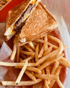 cheeseburger on white bread with fries