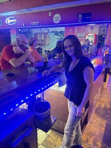 Bartender behind the bar with a customer on the other side