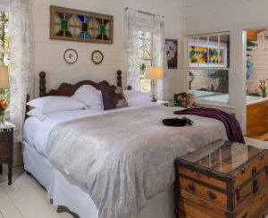 bedroom featuring antique furniture and jetted tub visible in the background