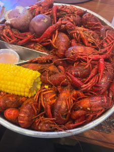 metal tray of boiled crawfish with corn and potatos