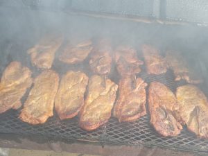 open barbque pit with port steaks on the grill