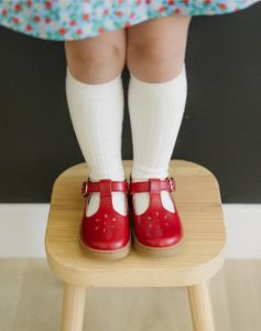 little's girl's feet with red shoes and long socks