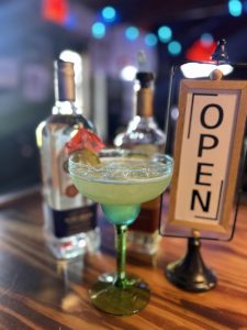 margarita with open sign and liquor bottles