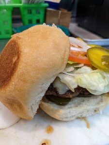burger with top bun leaning on the side