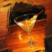 martini in a glass with olives on a wooden bar