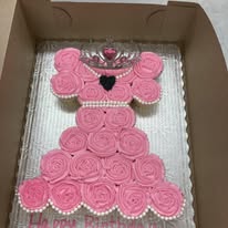 pink-iced cupcakes in the shape of a princess dress with a tiara