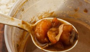 spoonful of seafood over a pot