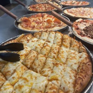 metal table with assorted pizzas