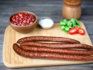 sausage on a cutting board with peppers and seasoning