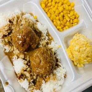 meatball stew plate lunch with corn and potato salad