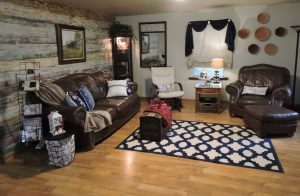 living room with leather furniture, one wall is wood planks