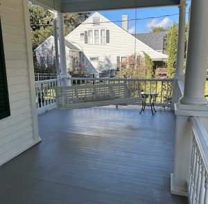 large, open porch with a swing hanging in the corner