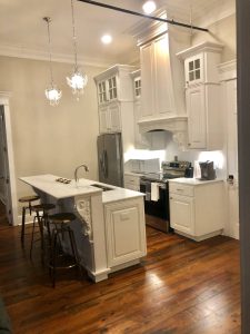 kitchen with high ceilings, white cabinets, and two chandeliers