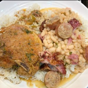 meat dish served over rice with beans and sausage