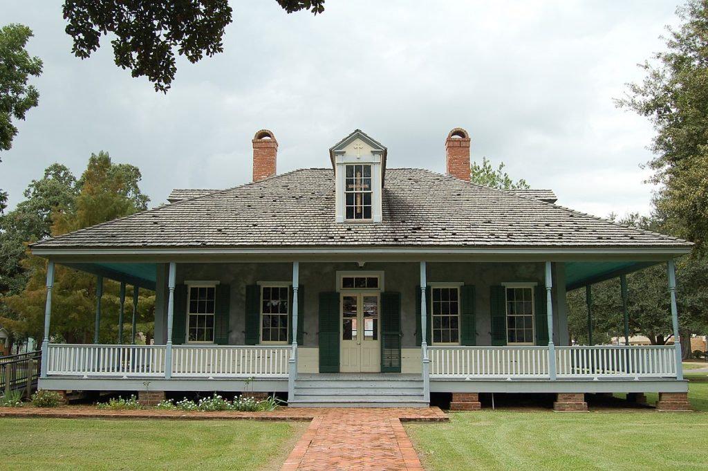 blue Acadian style house with large front porch, one dormer in he center, and two fireplaces, one on each side of the house