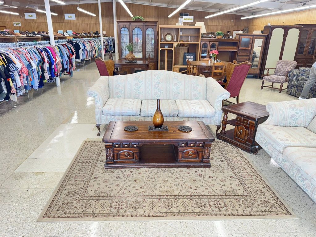 inside of thrift store with furniture in the center and clothes off to the side