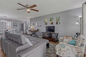 living room with gray paint and furniture. Also has a gray geometric-pattern rug