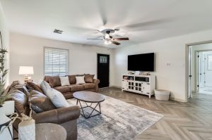 living room with brown leather furniture and a large neutral-colored rug