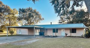 Front of house with metal roof and carport