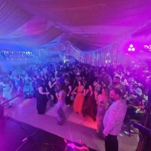 darkened room with people dancing at a Mardi Gras Ball