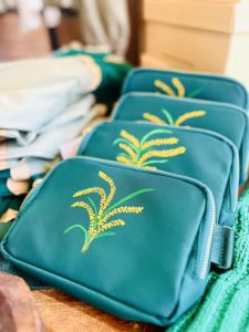 row of blue purses with hand-painted rice stalks