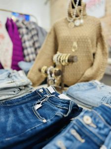 gold sweater in the background with jeans in the foreground