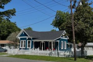 exterior of historic blue home with white trim and white picket fence