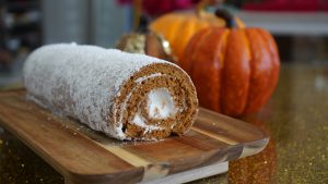 pumpkin roll with pumpkin decorations in the background