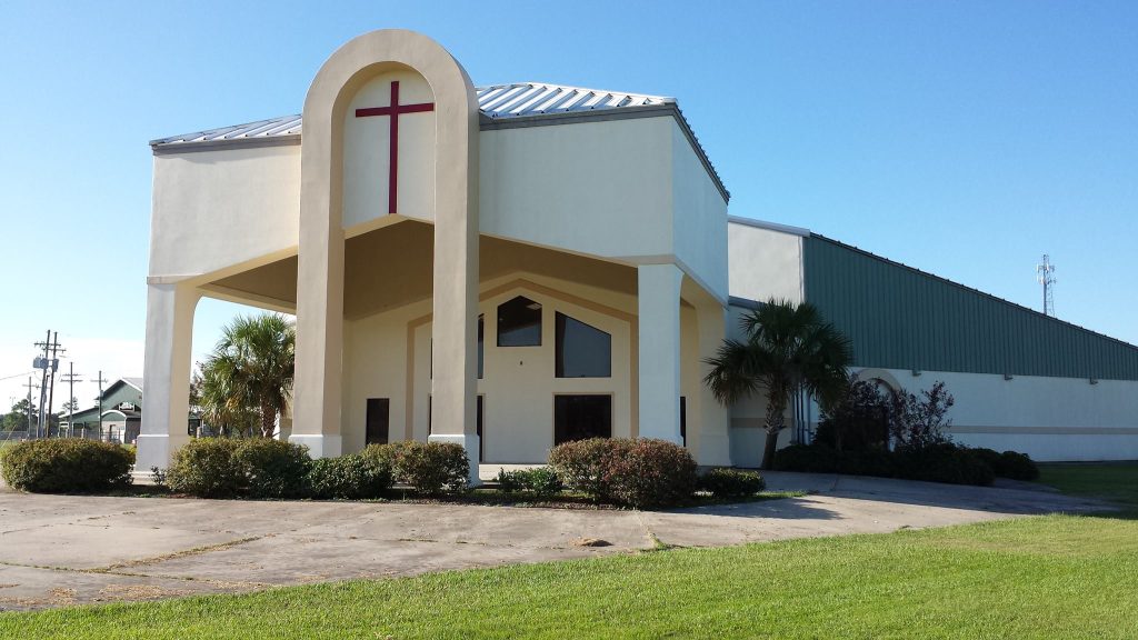 off-white church building with circular drive