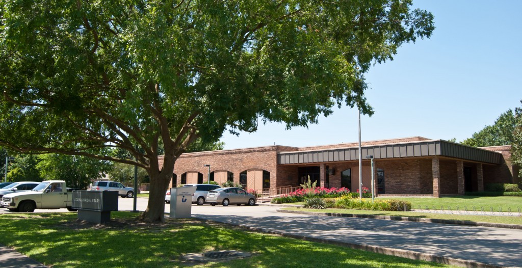 brick library building in the back with a large tree in the foreground