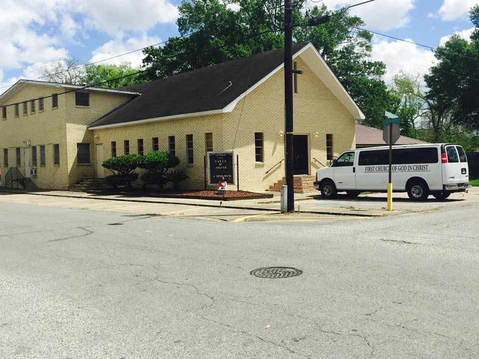 tan-brick church building with white church van outside