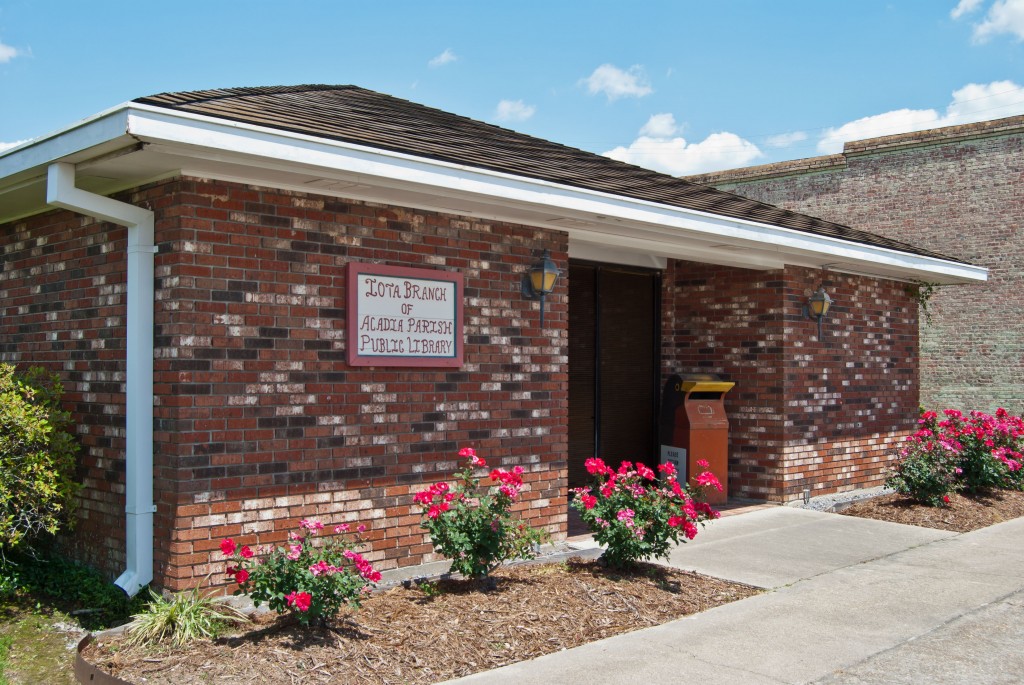 brick library building with flower bushes out front
