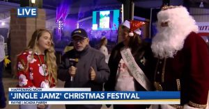 still frame of a news reporter speaking to pageant queen and Santa Clause