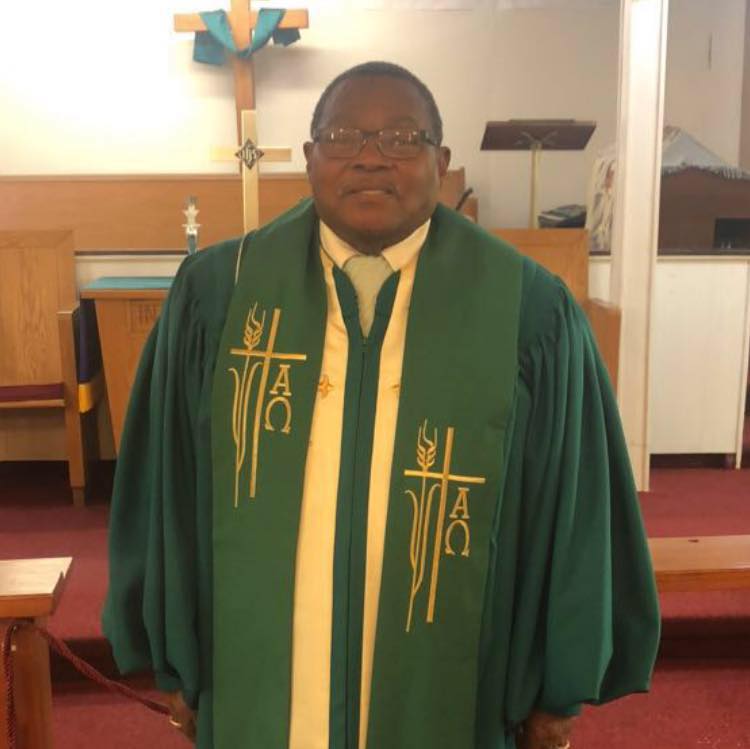 man in church in green pastorial robes