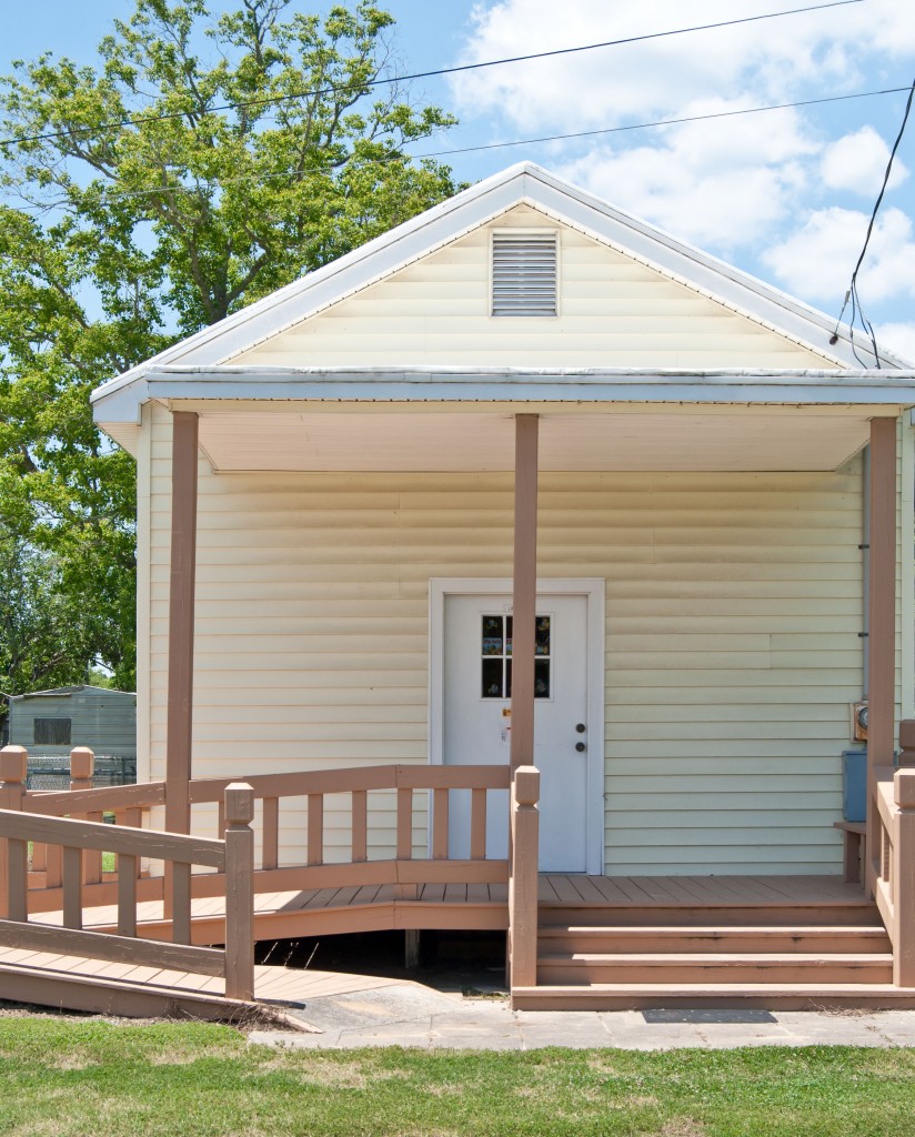 small yellow building with steps and handicap ramp out front