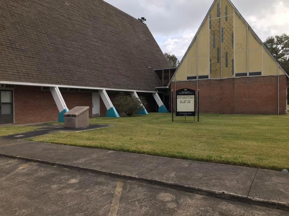 church building with courtyard and sign