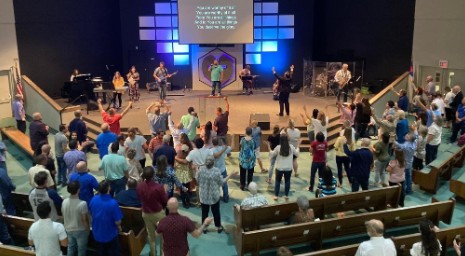 church members standing in worship, view from balcony above