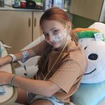 young girl in a hospital bed with IVs, etc.