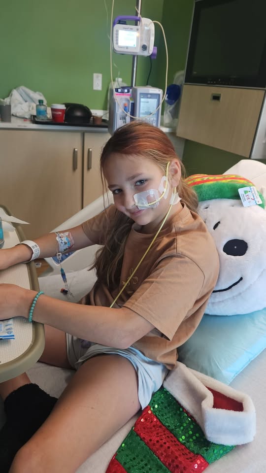 young girl in a hospital bed with IVs, etc.