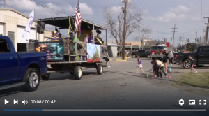 parade float with children running for goodies on the ground
