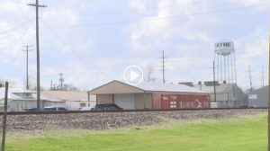 railroad tracks and power lines in the foreground with a Rayne water tower in the background