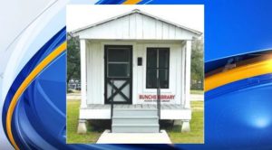 small white wooden building with front porch and black screen door
