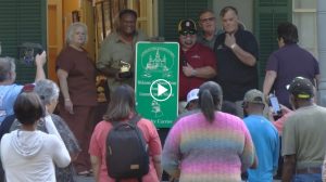 Crowd gathered around Grammy-Winning musician Chubby Carrier with a sign being unveiled that will signify Church Point, Louisiana as his hometown