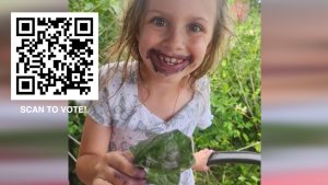 Young girl with stained face holding a leaf
