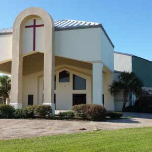 off-white church building with circular drive