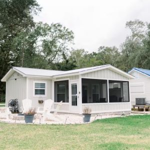 exterior of small cottage with screened in porch in front