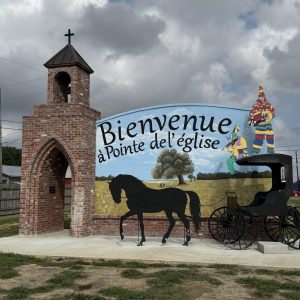 Town welcome sign written in French with horse and buggy cutout